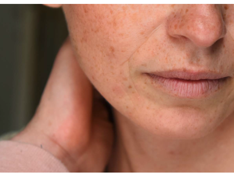 Close up image of the lower half of a woman's face and hand